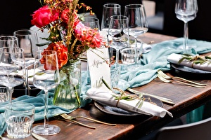 opgedekte tafel tijdens bruiloft met linnen servetten en bloemen. 